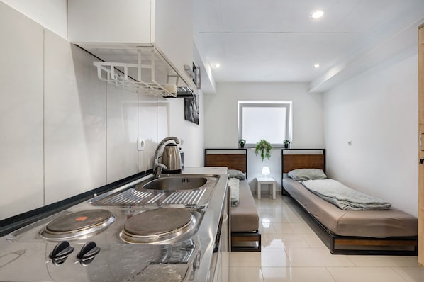A compact kitchen with a stove, sink, and a small dining area.