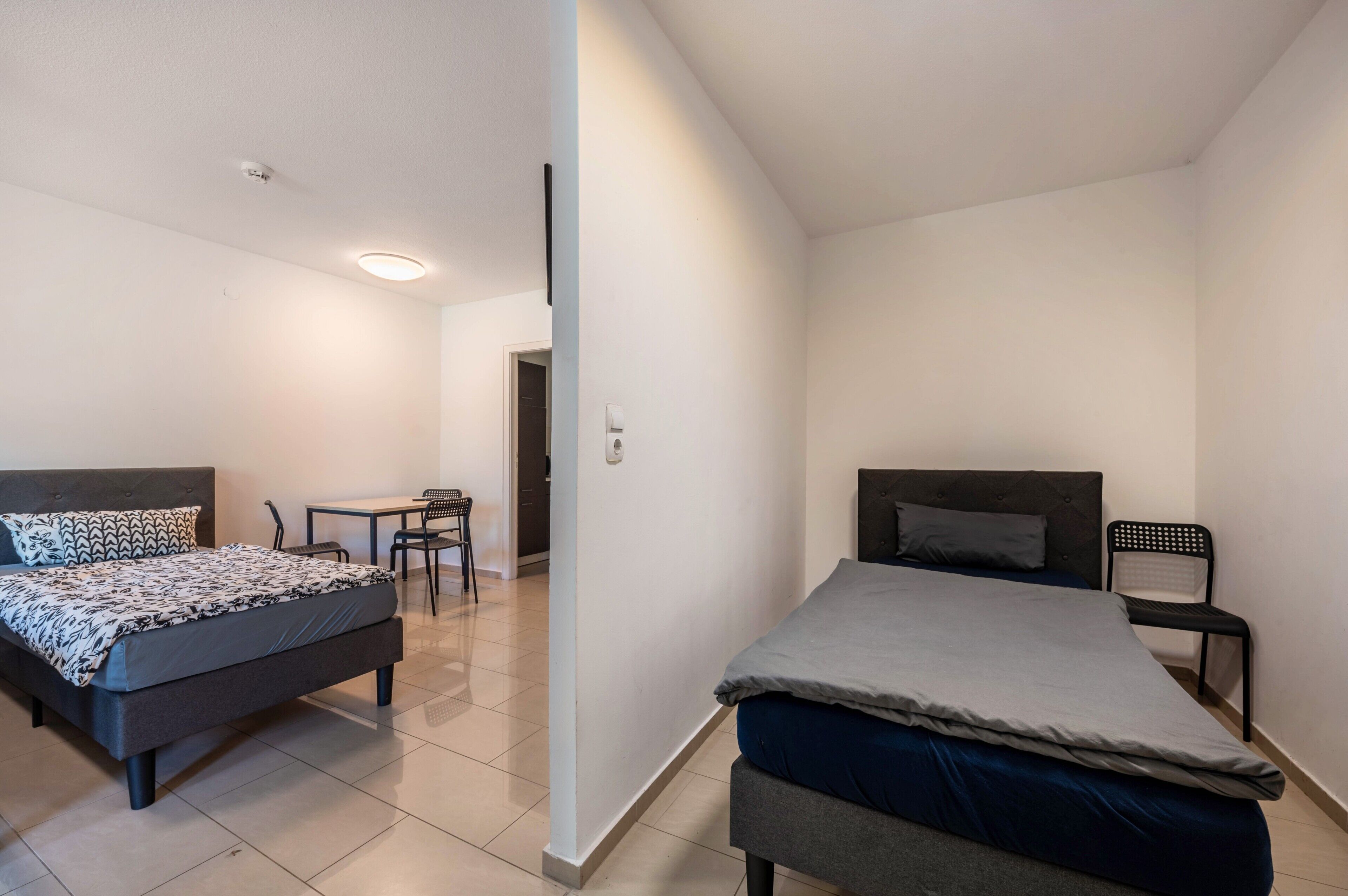 Une chambre avec deux lits, un bureau et une chaise.