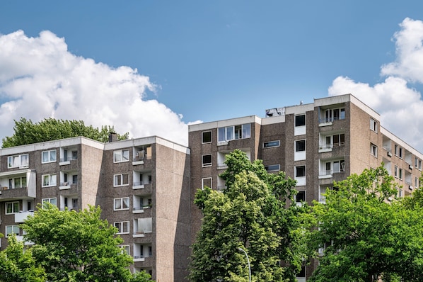 A multi-story residential building with balconies, windows, and a clear sky.