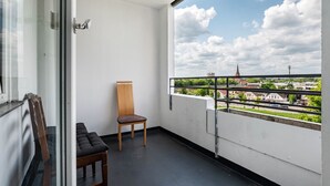 A balcony with a view of a town, a chair, and a bench. - Apartment 'Mk Delmenhorst 21' with Wi-Fi (Delmenhorst)