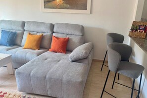 A living room with a grey sofa, two armchairs, and a coffee table.