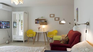 A modern living room with a red sofa, yellow chairs, a white cabinet, and a television.