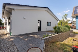 Un bâtiment moderne doté d’un toit plat, d’une petite entrée et d’une allée pavée.