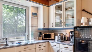 A modern kitchen with white cabinets, a built-in microwave, and a stainless steel refrigerator. - Holiday Home 'Hafenblick' with Private Terrace, Private Garden and Wi-Fi (Walchum)