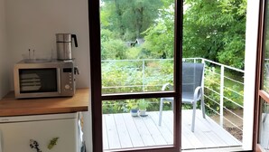 Una cocina equipada con microondas, cafetera y refrigerador.
