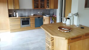 Una cocina moderna con armarios de madera, lavavajillas, estufa y cafetera.