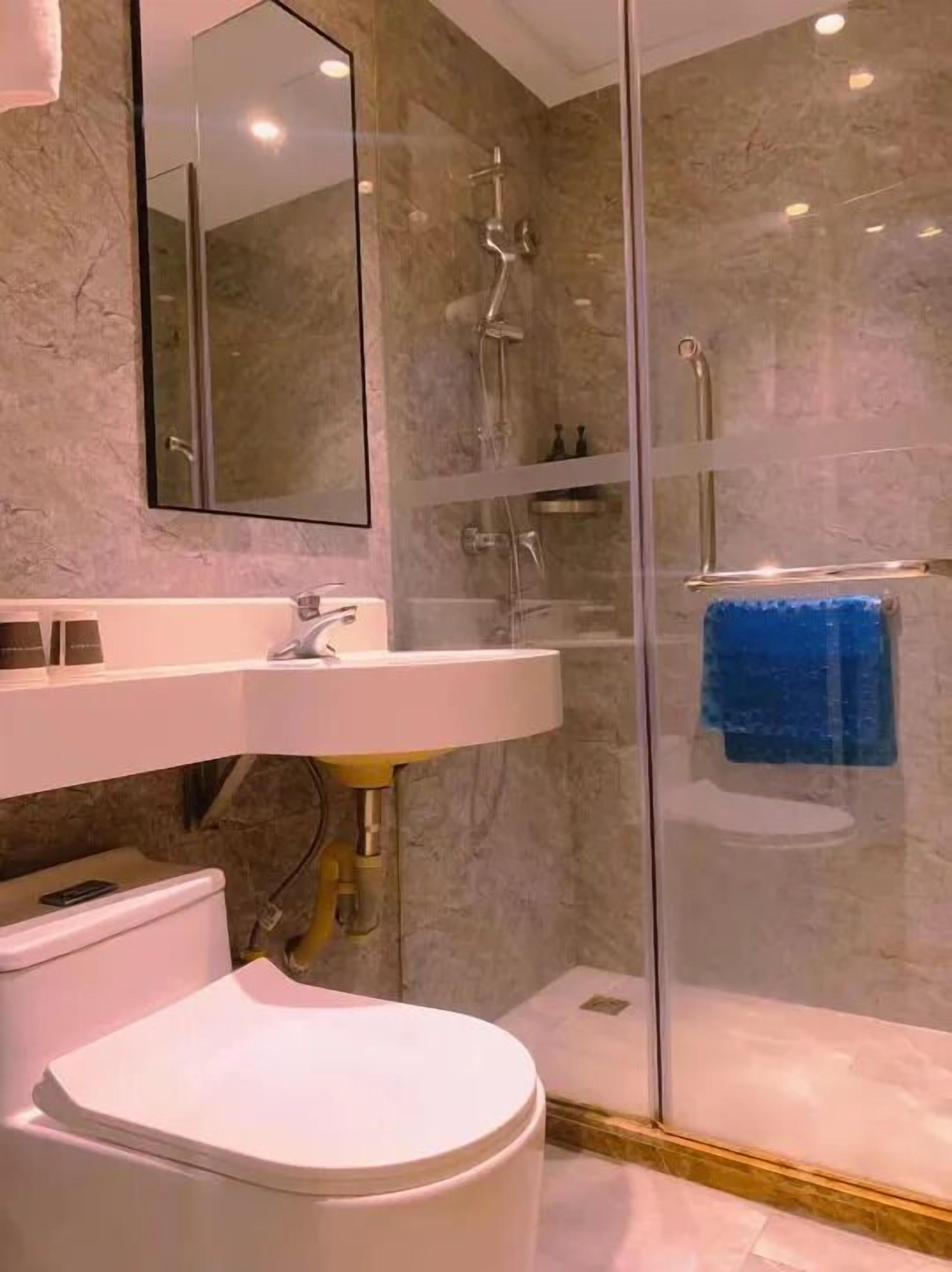 Une salle de bain moderne avec une douche à parois de verre, un lavabo blanc et des toilettes.