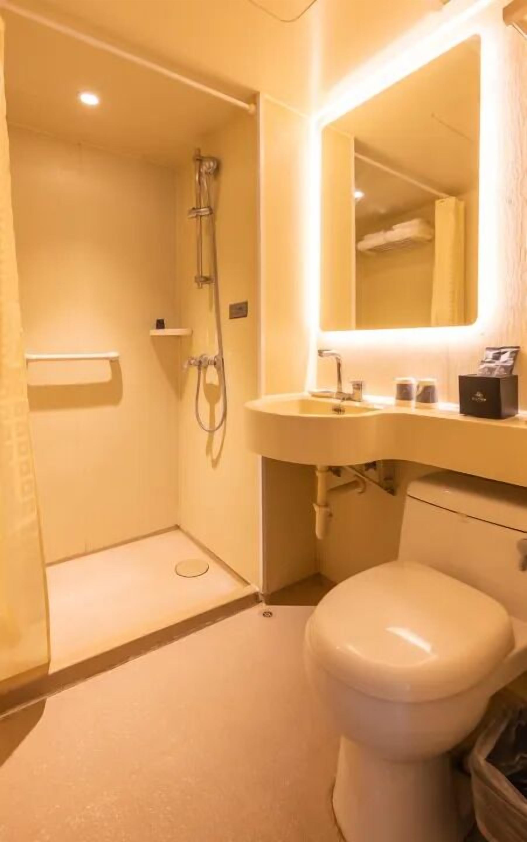 Une salle de bain avec des toilettes, un lavabo et une douche.