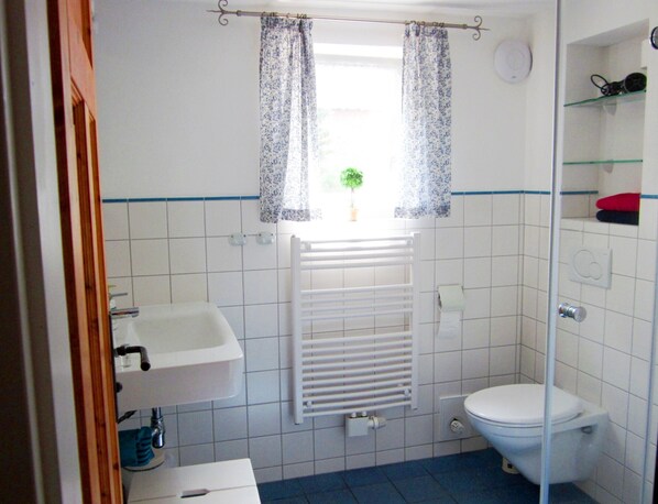 Un baño con inodoro, lavabo y ducha.