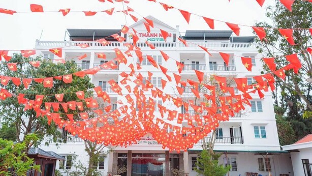 Ein Hotel mit weißer Fassade, Balkonen und einem Schild mit der Aufschrift "THANH NAM HOTEL".