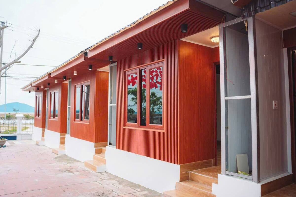 Een modern gebouw met een rood-wit uiterlijk, grote ramen en een zichtbare trap naar de ingang.