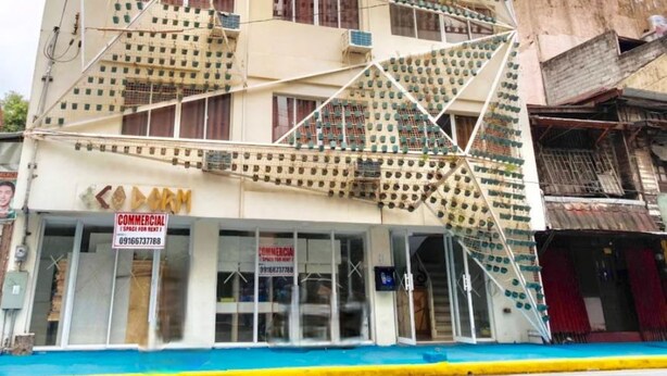A multi-story building with a unique facade featuring numerous square windows and balconies. - Jardin Oriental Suites Ubelt Manila (Manila)