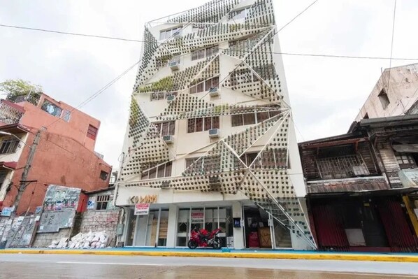 A multi-story building with a unique geometric facade, featuring a series of balconies and windows. - Jardin Oriental Suites Ubelt Manila (Manila)