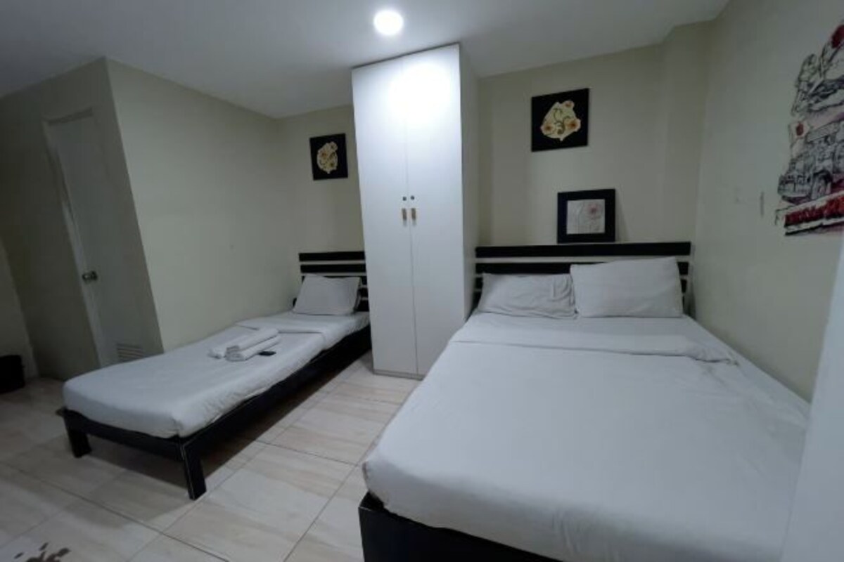 A room with two single beds, a wardrobe, and a door.