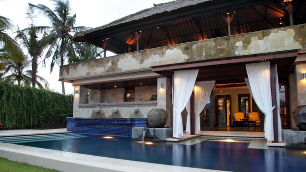A resort with a swimming pool, a covered outdoor area, and a building with stone walls and a tiled floor. - Villa Amani (Tabanan)