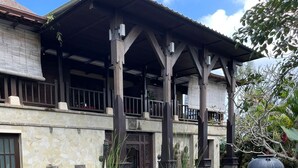A traditional building with a covered patio, stone pathway, and a water feature. - Villa Amani (Tabanan)