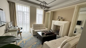 A modern living room with a sofa, a coffee table, a fireplace, and a desk with a computer. - Haoting International Hotel (Beijing)