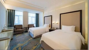 A hotel room with two beds, a desk, a chair, and a large window. - Haoting International Hotel (Beijing)