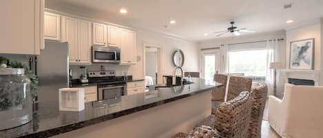 Enjoy cooking in this well-equipped kitchen with a sleek island, sink, and stainless steel appliances.