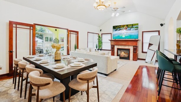 A spacious living room with a fireplace, a dining area with a large table and chairs, and a television mounted on the wall. -   Heated Pool Hot Tub PicklebalMovieTheaterPoolTable GameR Golf (Des Moines)