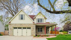 A two-story house with a stone facade, a garage, and a covered porch. -   Heated Pool Hot Tub PicklebalMovieTheaterPoolTable GameR Golf (Des Moines)
