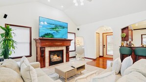 A spacious living room with a fireplace, a large flat-screen TV, and a comfortable seating area. -   Heated Pool Hot Tub PicklebalMovieTheaterPoolTable GameR Golf (Des Moines)