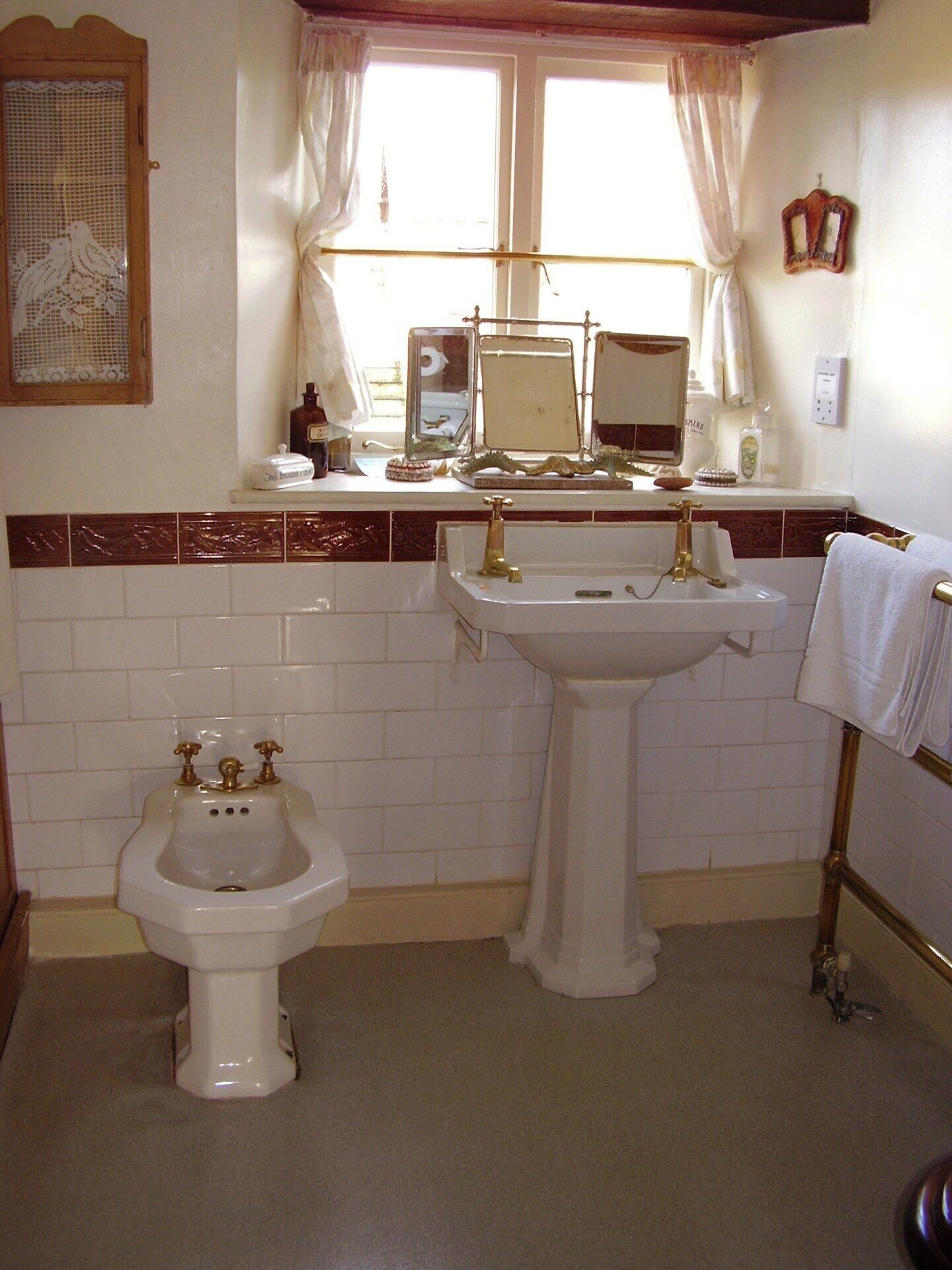 Un baño con bidé, lavamanos y espejo.