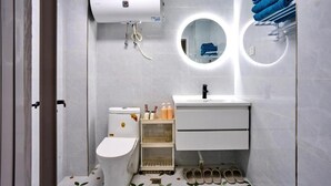 A modern bathroom with a toilet, sink, and towel rack. - Xi'an Hills Lostwine Boutique Retreat (Xi'an)