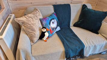 Relax in this inviting space with a comfortable sofa, plush pillows, and a cozy throw blanket.