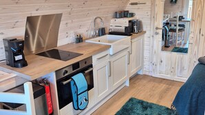 Una cocina compacta con armarios de madera, un lavamanos y una estufa.