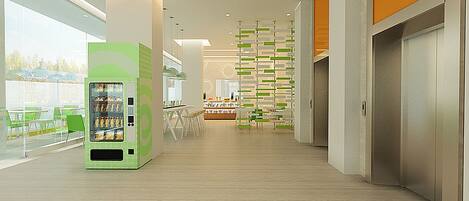 A modern interior with a vending machine, a dining area, and a reception desk.