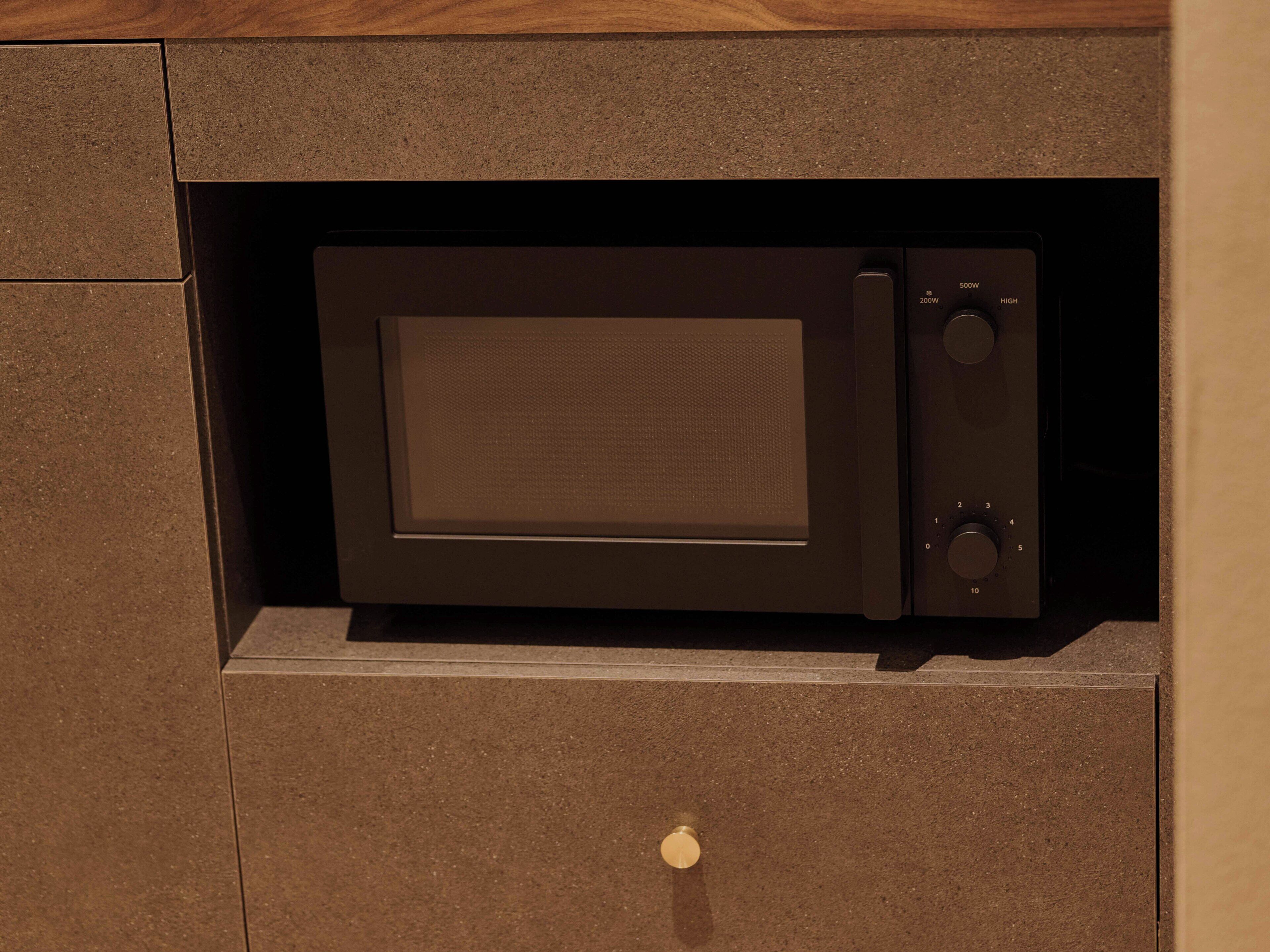 A microwave oven built into a cabinet with a control panel on the right side.
