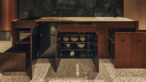 A modern kitchen with a dark backsplash, a stainless steel refrigerator, and a built-in wine rack. - illi Tria Shibuya (Tokyo)