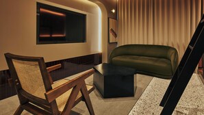 A modern living room with a television, a green sofa, a wooden chair, and a black coffee table. - illi Tria Shibuya (Tokyo)