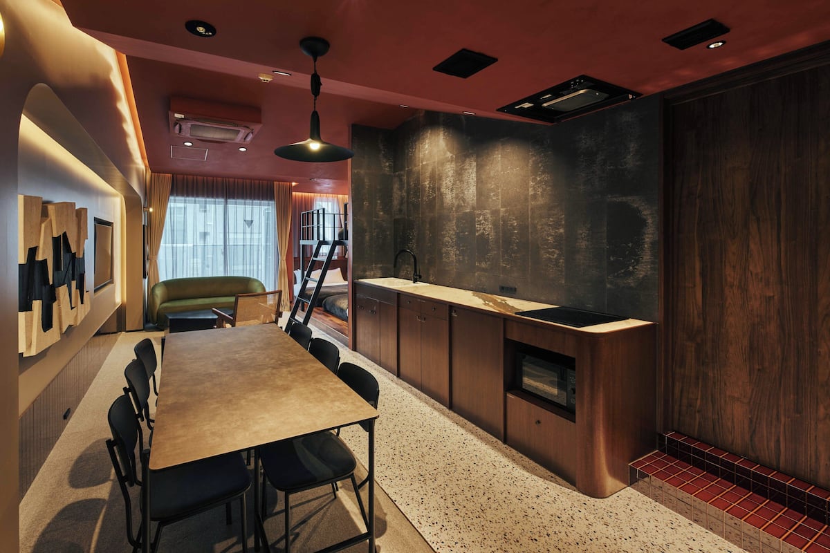 A modern kitchen with a wooden countertop, a built-in microwave, and a dark backsplash.