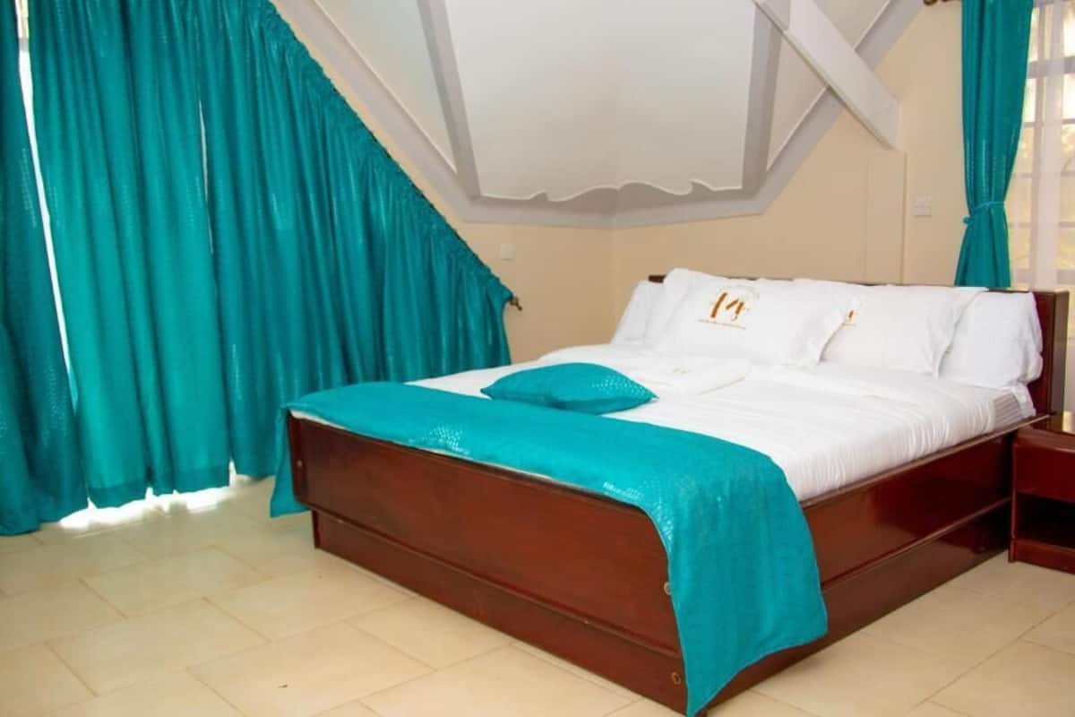 Une chambre à coucher avec un lit en bois, des rideaux turquoise et un baldaquin blanc.