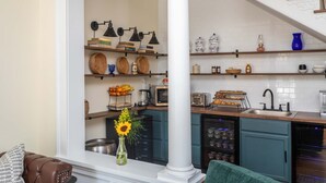 A kitchen with wooden shelves, a microwave, a toaster, and a sink. - The Legacy Suites Collection Full Property Rental (Luray)