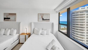 Ein Hotelzimmer mit zwei Betten, einem Nachttisch und Bildern an den Wänden.