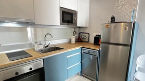 Une cuisine moderne dotée d’appareils électroménagers en acier inoxydable, d’un évier et de meubles de couleur bleu clair.