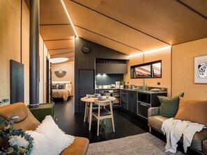 A modern interior with a dining area, kitchen, and seating space. - Skylark Cabin – Private Luxury Escape with Hot Tub (Ben Ohau)