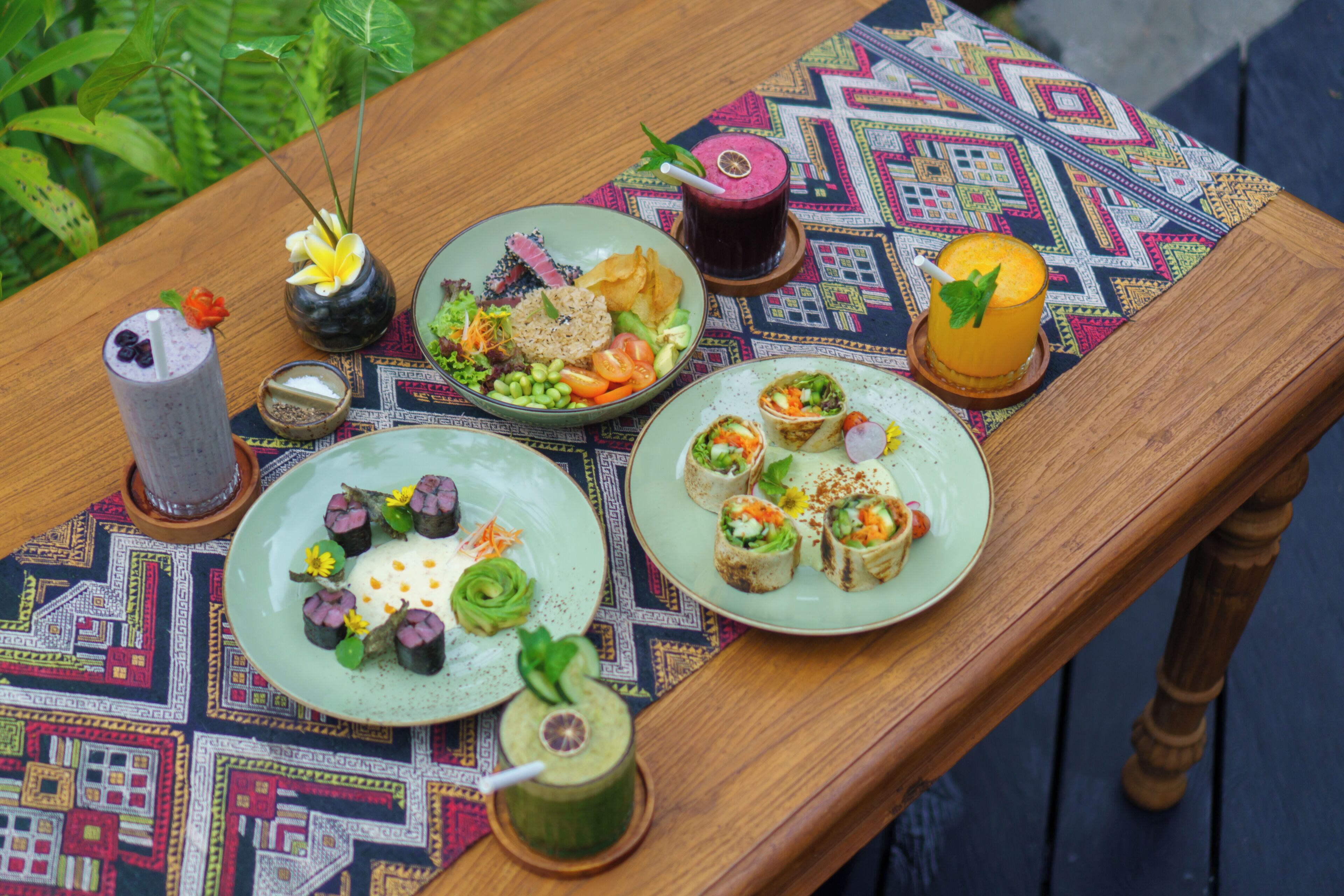 Een tafel met diverse gerechten, drankjes en een decoratief middelpunt.