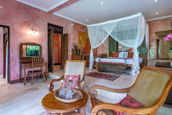 A room with a bed under a canopy, a desk with a chair, and a television. - Lumina Sanctuary (Ubud)