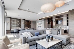 Relax in a stylish space with a large L-shaped sofa, coffee table, and modern bar setup.