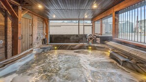 A hot tub with a wooden interior and large windows. - Historic Yellowstone Saloon |Sleeps 25, Hot Tub, Pool Table & More! (Ashton)