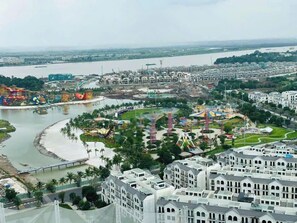 A coastal cityscape with a river, a theme park, and residential buildings. - Vinhomes Grand Park Luxury Apartments  (Ho Chi Minh City)