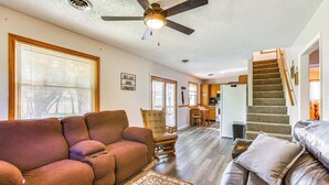 A spacious living room with a brown leather sofa, a patterned rug, and a ceiling fan. - Countryside Escape 14 Mi to Milford & Geary Lakes! (Chapman)
