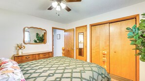 A bedroom with a bed, wooden wardrobe, a ceiling fan, and a mirror. - Countryside Escape 14 Mi to Milford & Geary Lakes! (Chapman)