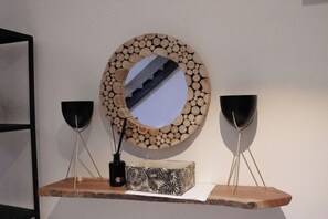 Simple, modern space with a wooden shelf, decorative mirror, and patterned box.