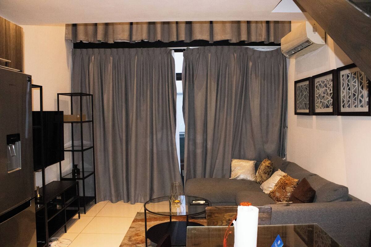 Ein Wohnzimmer mit einer Couch, einem Couchtisch, einem Fernseher und einem Bücherregal.