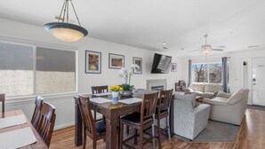 A dining area with a wooden table and chairs, a vase with flowers, and a ceiling fan. - Best View! 6 Pools & 4 Hot Tubs! Waterslides! Sport Courts! Remodeled! Location! (St. George)